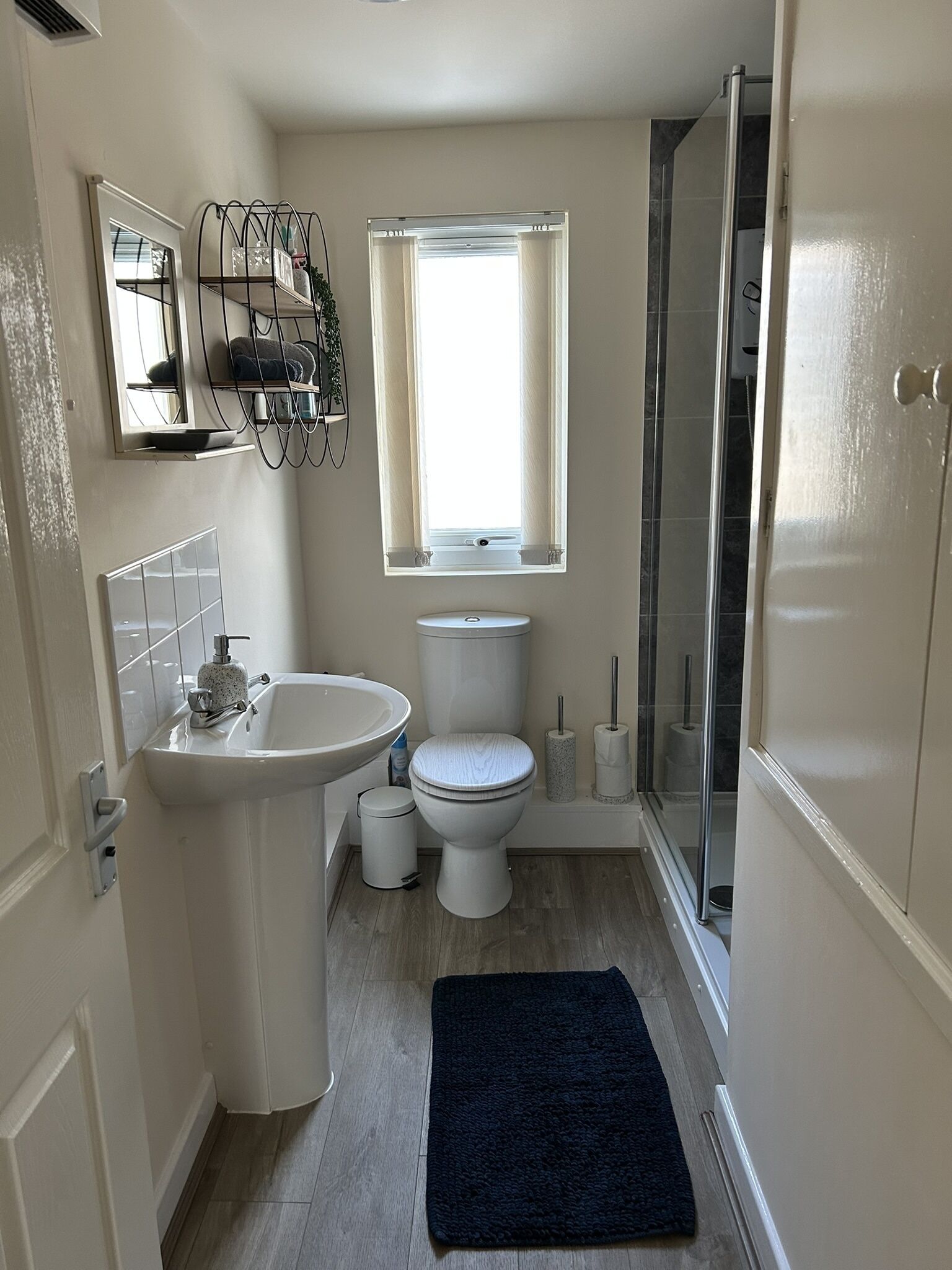 A compact bathroom with a sink, toilet, and shower.