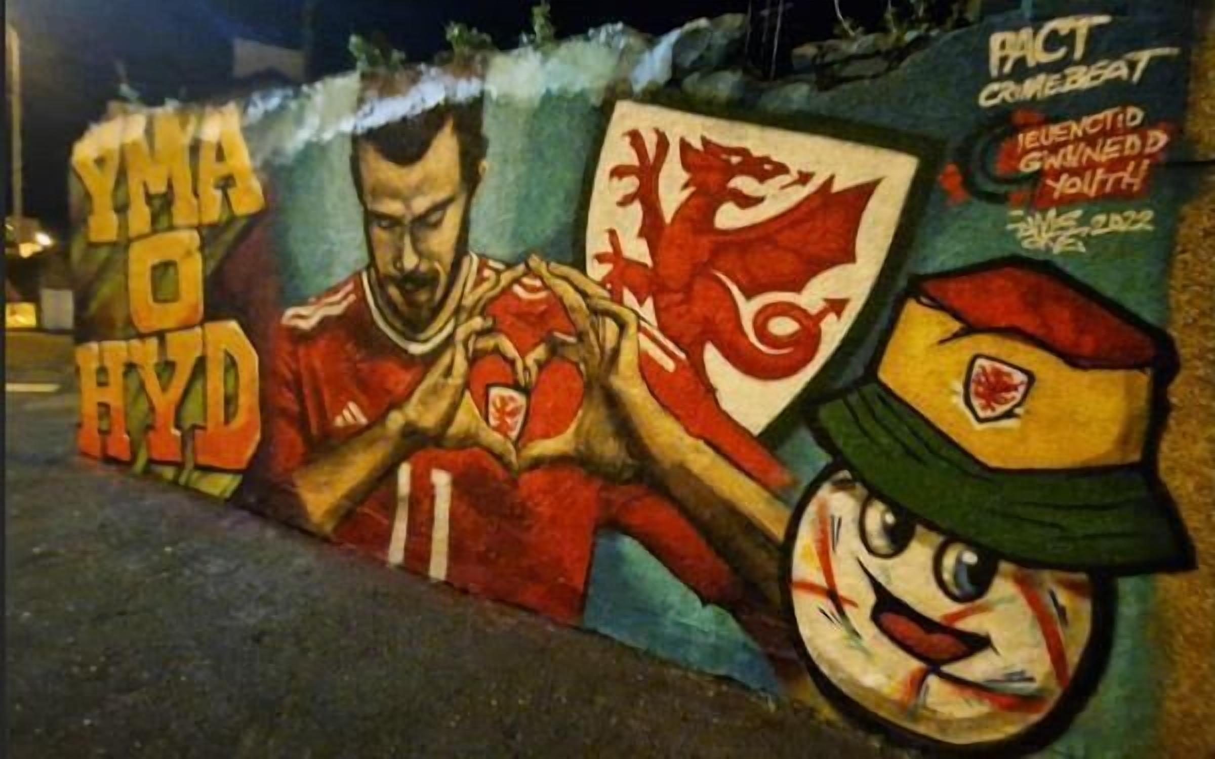 A mural with a football player and a mascot, featuring text that reads "YMAO HYD" and "ACT CRIMEBEAT".