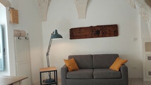 A living room with a grey sofa, wooden table, and lamp.