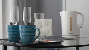 A tray with two blue mugs, a white mug with a gold stripe, and a white ceramic mug with floral patterns. - The Catherdral Rooms (Málaga)