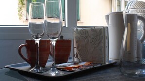 A tray with wine glasses, a coffee maker, and a decorative item on a table by a window. - The Catherdral Rooms (Málaga)