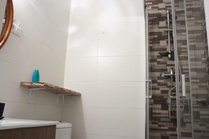 Un baño con ducha, inodoro y lavabo.