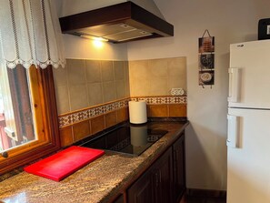 A kitchen with a red cutting board, a white refrigerator, and a patterned backsplash. - Rural house in a valley with sea views and swimming pool. (Tegueste)