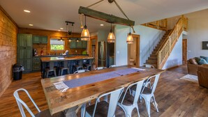 A spacious kitchen with wooden cabinets, a central island, and pendant lighting.