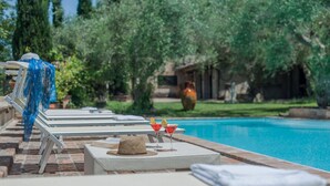 A poolside area with lounge chairs, a book, a hat, and two martini glasses with lemon slices. - Villa Cavalli - Private villa, 4 bedrooms, pool, A/C, wifi, nature, Marche (Vallefoglia)
