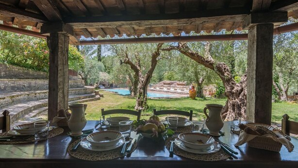 A dining table set outdoors with a view of a swimming pool and garden. - Villa Cavalli - Private villa, 4 bedrooms, pool, A/C, wifi, nature, Marche (Vallefoglia)