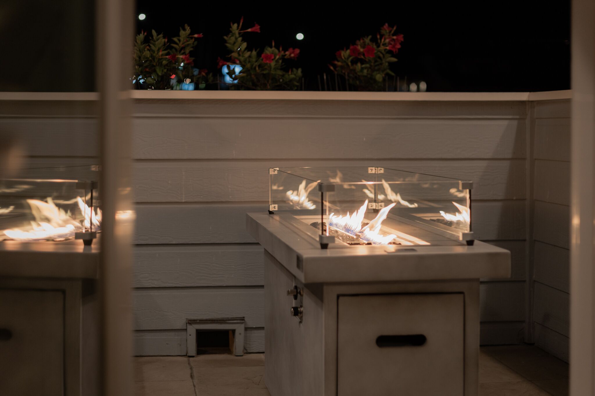 A patio with a built-in fire feature and a small enclosed area.