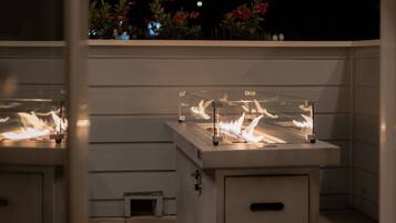 A patio with a built-in fire feature and a small enclosed area.