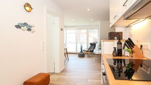 Een moderne keuken met een houten aanrecht, een bankje en een eethoek met een stoel.