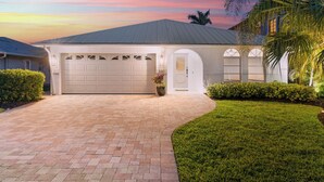 A house with a garage, a driveway, and a well-maintained lawn.