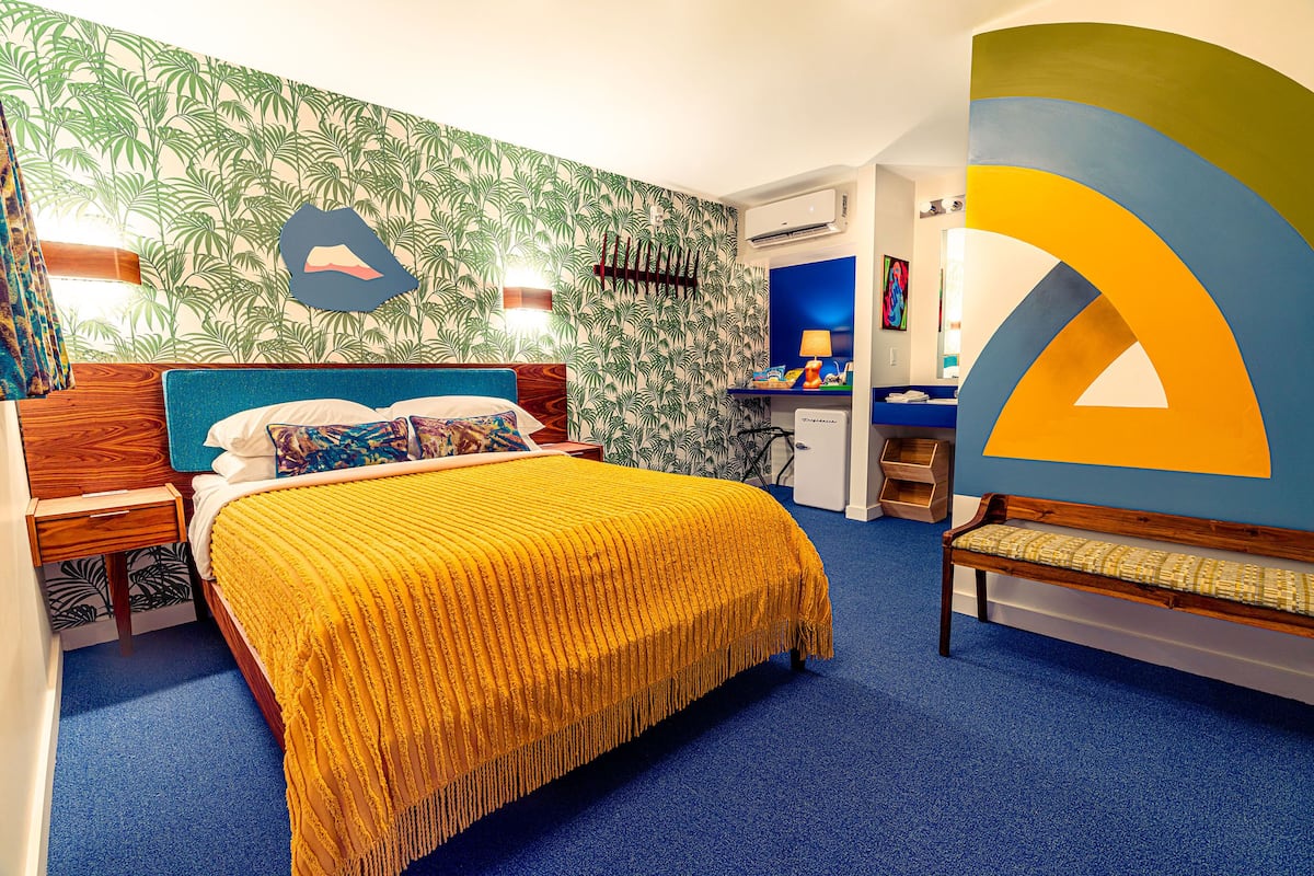 Une chambre d’hôtel avec un lit, un bureau, une chaise et une salle de bain.