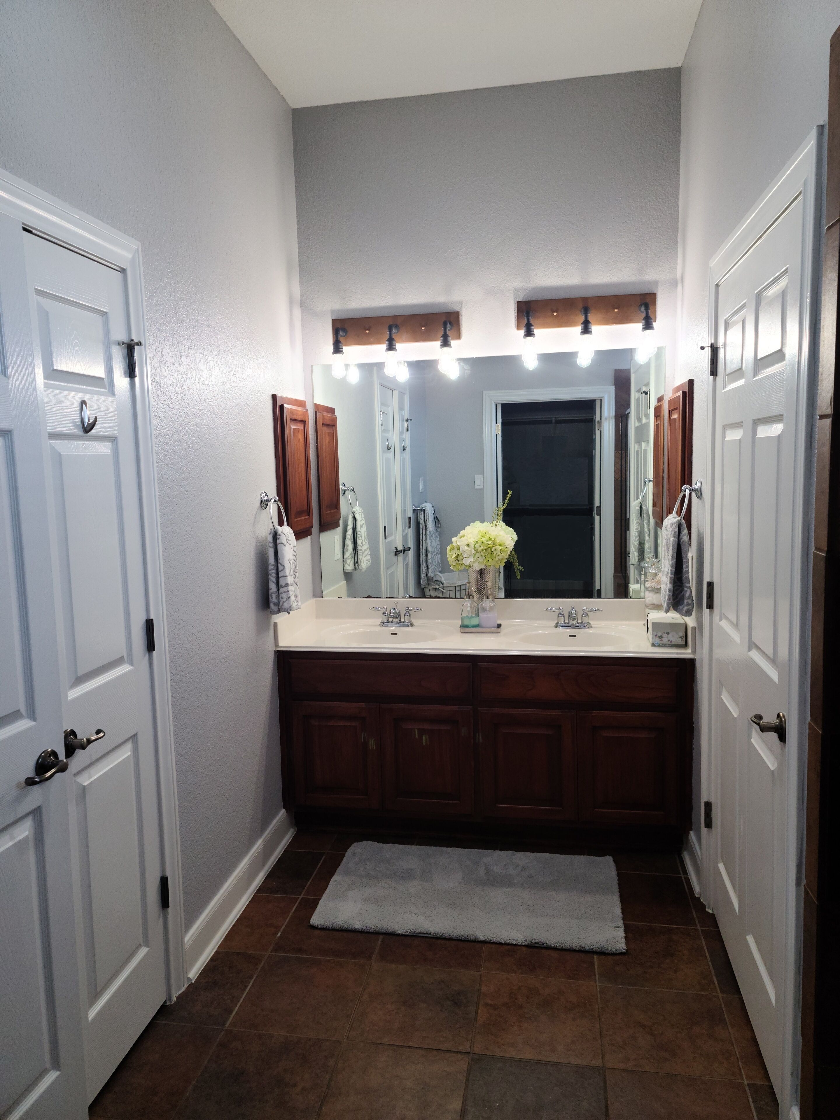 A bathroom with a large vanity, a mirror, and a lighted vanity area.