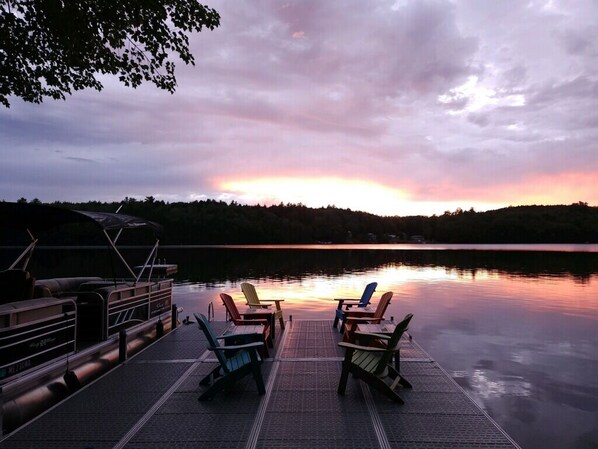 A dock with chairs facing a calm lake at sunset. - Lake Front with Amazing Sunsets on McGrath Pond (Oakland)