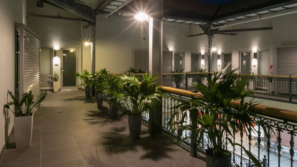 A covered outdoor area with potted plants, a tiled floor, and a railing. - Suite 1 with Kitchenette (St. John)
