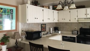 A kitchen with white cabinets, a microwave, a coffee maker, and a sink. - Cozy Mountain Retreat in Snowmass Village CO (Snowmass Village)