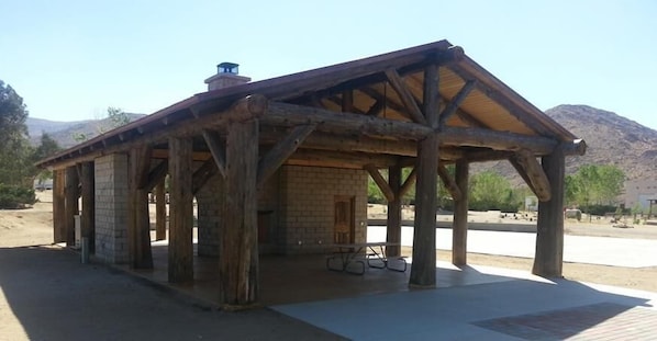 A rustic wooden structure with a pitched roof, brick walls, and a chimney. - Stagecoach Trails RV Resort (Julian)