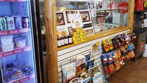 A vending machine with Coca-Cola and Dr. Pepper, a display of books, and a variety of snacks.