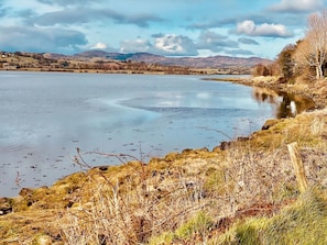 A calm lake with rocky shores and sparse vegetation. - Riverside Cottage, Ramelton, The Wild Atlantic Way (Ramelton)