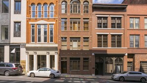 A row of multi-story buildings with various architectural styles, including brick and stone facades, and a street with parked cars. - The Parton Printer's Alley Nashville- 2 Blocks to Broadway (Nashville)