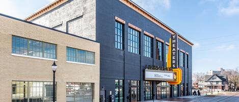 A building with a sign reading "Theaters" and "Living Room." It features large windows and a brick facade.