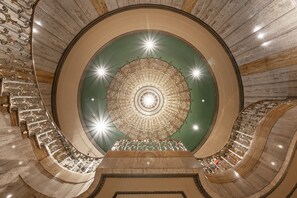 A grand, circular atrium with a central ornate ceiling and a spiral staircase. - Bottleworks Hotel (Indianapolis)