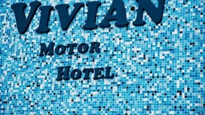 Un mur recouvert de mosaïques, sur lequel on peut lire en lettres bien visibles : « VIVIAN MOTOR HOTEL ».