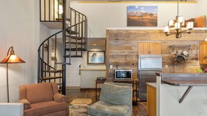 A modern kitchen with a wooden accent wall, a built-in microwave, and a stainless steel refrigerator.