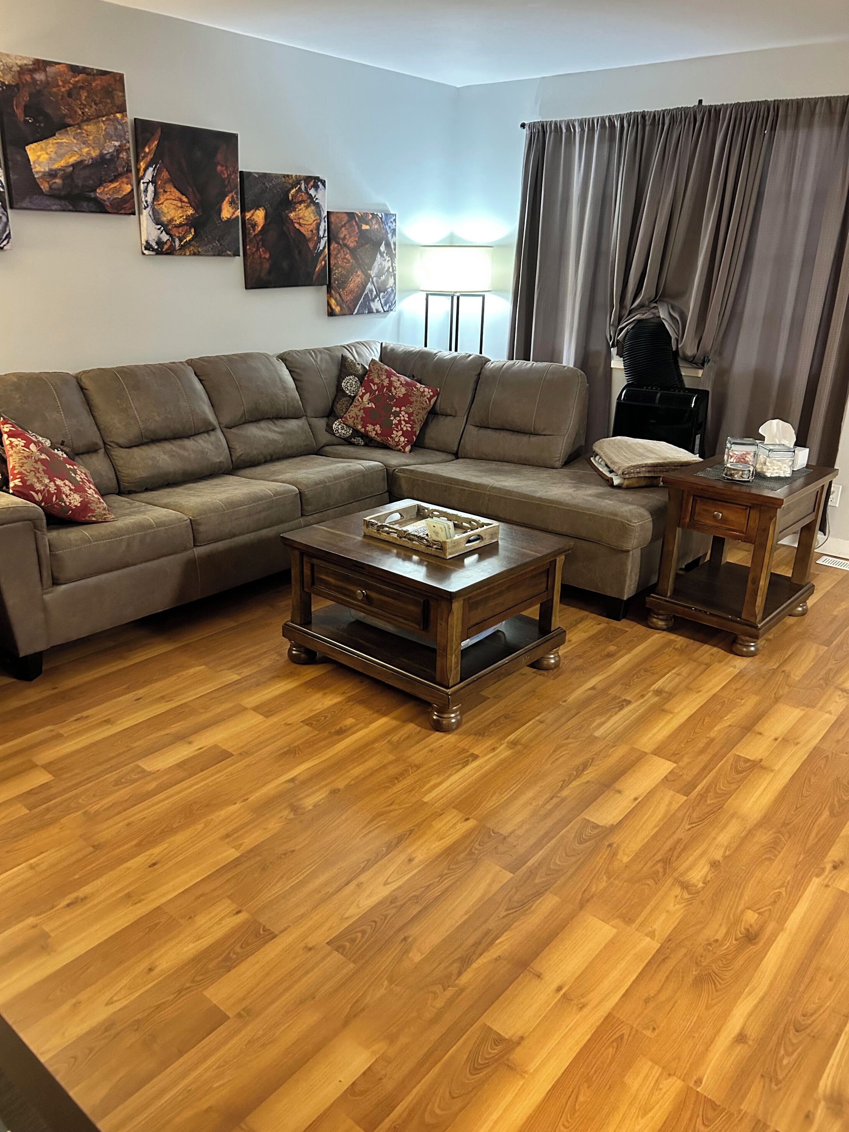 A living room with a sectional sofa, two coffee tables, and a small side table.