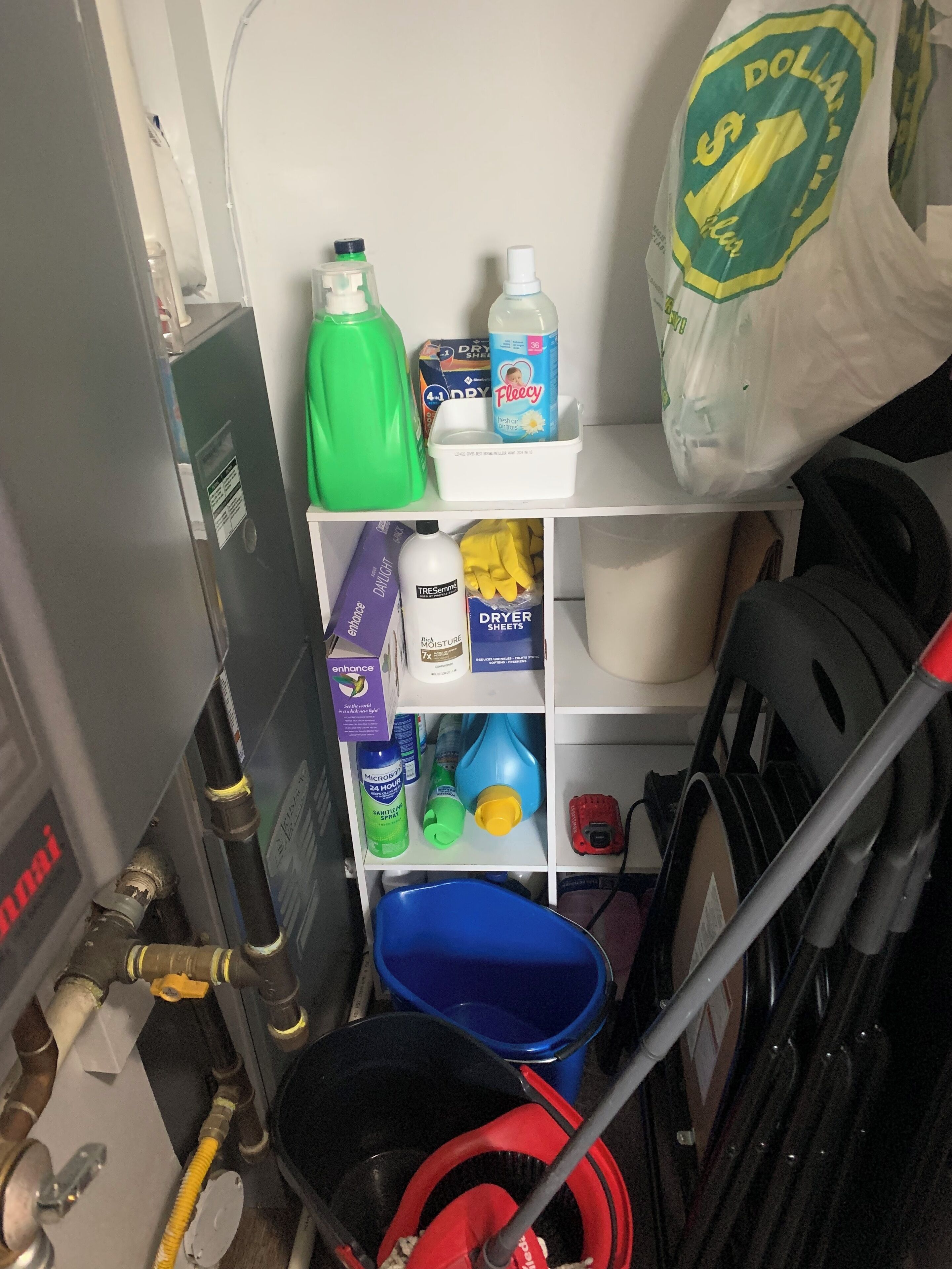 A storage area with cleaning supplies, a blue bucket, and a red mop.