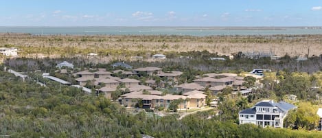 A coastal residential area with multiple houses, a bridge, and a view of the ocean.