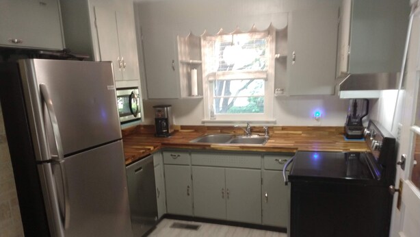 A compact kitchen with a refrigerator, sink, and a coffee maker. - Mid Century Modern McKenzie (McKenzie)
