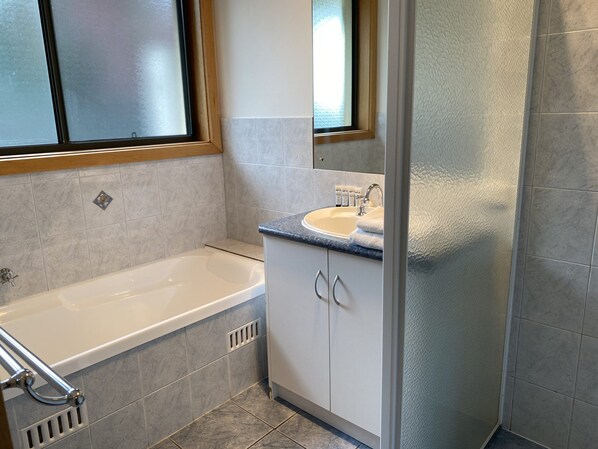 A bathroom with a bathtub, a sink, and a shower area. - Dolphin Court - Park your car and walk to all that Robe has to offer (Robe)