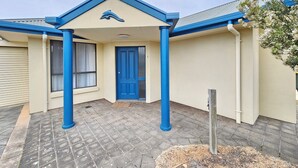 A building with a blue door and columns, a tiled entrance area, and a clear sky. - Dolphin Court - Park your car and walk to all that Robe has to offer (Robe)