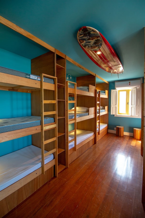 A room with bunk beds, a surfboard, and a window with shutters. - LONGBOARD PARADISE SURF CLUB (Rio de Janeiro)