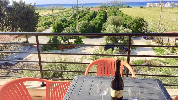 A balcony with a table, two wine glasses, and a bottle of Otelello Celler wine. - Stunning 2-bed Apartment in Poli Crysochous (Polis)
