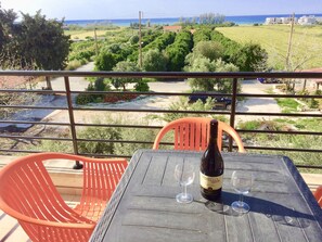 A balcony with a table, two wine glasses, and a bottle of Otelello Celler wine. - Stunning 2-bed Apartment in Poli Crysochous (Polis)