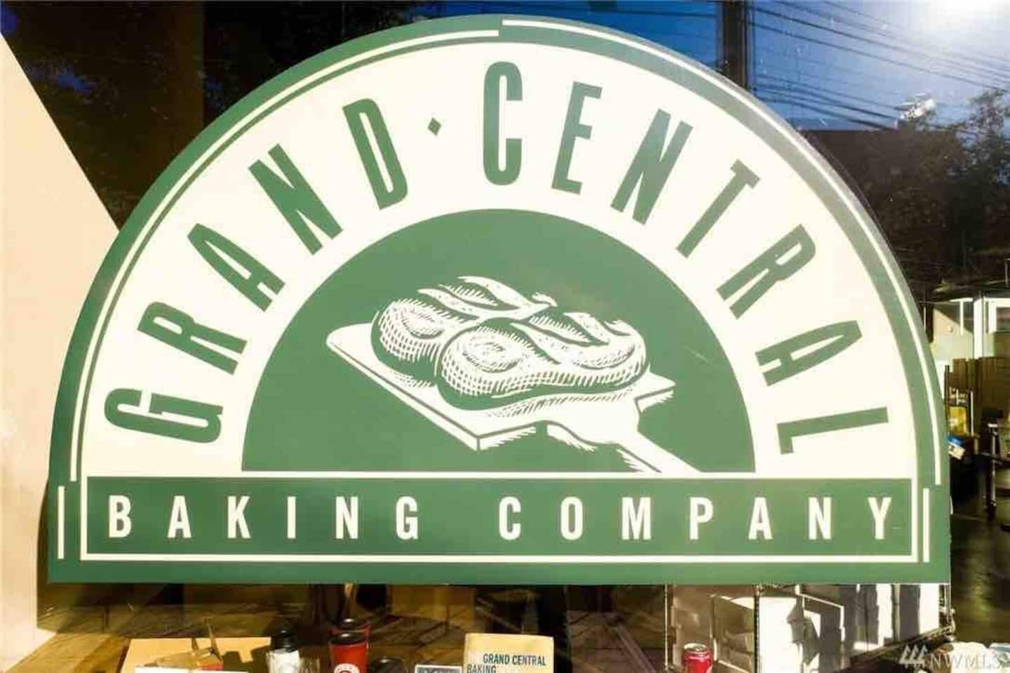 A sign for Grand Central Baking Company with a depiction of baked goods.