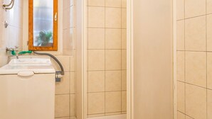 Une salle de bain avec une douche, un lavabo et des toilettes.