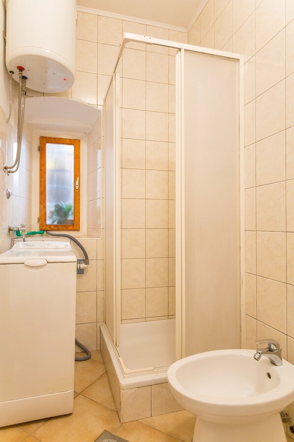 A bathroom with a shower, a sink, and a toilet.