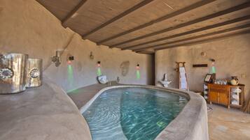 Relax by the serene indoor pool, surrounded by natural elements and rustic charm.