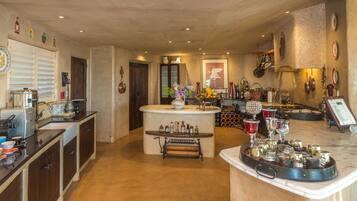 A spacious kitchen with a central island, wooden cabinets, and a variety of kitchenware and appliances.