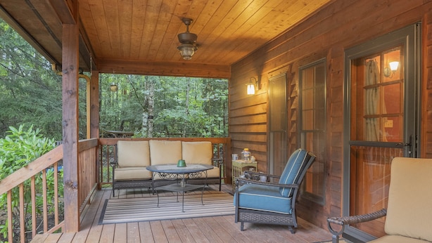 A wooden deck with a sofa, a chair, and a table. - Smokies Hideaway -  2 bdrms/2 bath, private, SECLUDED, BONFIRE pit, Large driveway (Townsend)