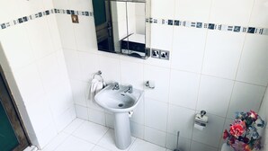 A bathroom with a sink, mirror, toilet, and a vase of flowers. - 🌟🧡FREE AIRPORT/BUS TERMINAL TRANSPORTATION (Kumasi)