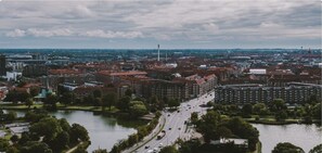 Panoramic cityscape with a river running through the center, surrounded by a mix of residential and commercial buildings.