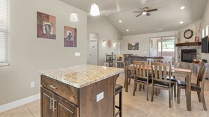 A spacious kitchen with granite countertops, wooden cabinets, and a dining area with wooden chairs and a table. - Park View Place with RV Parking! (Washington)
