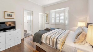 A bedroom with a bed, a TV, a dresser, and a ceiling fan. - Modern Twist + Old World Charm ~ 3Bed/2Bath/2Car (Kedron)
