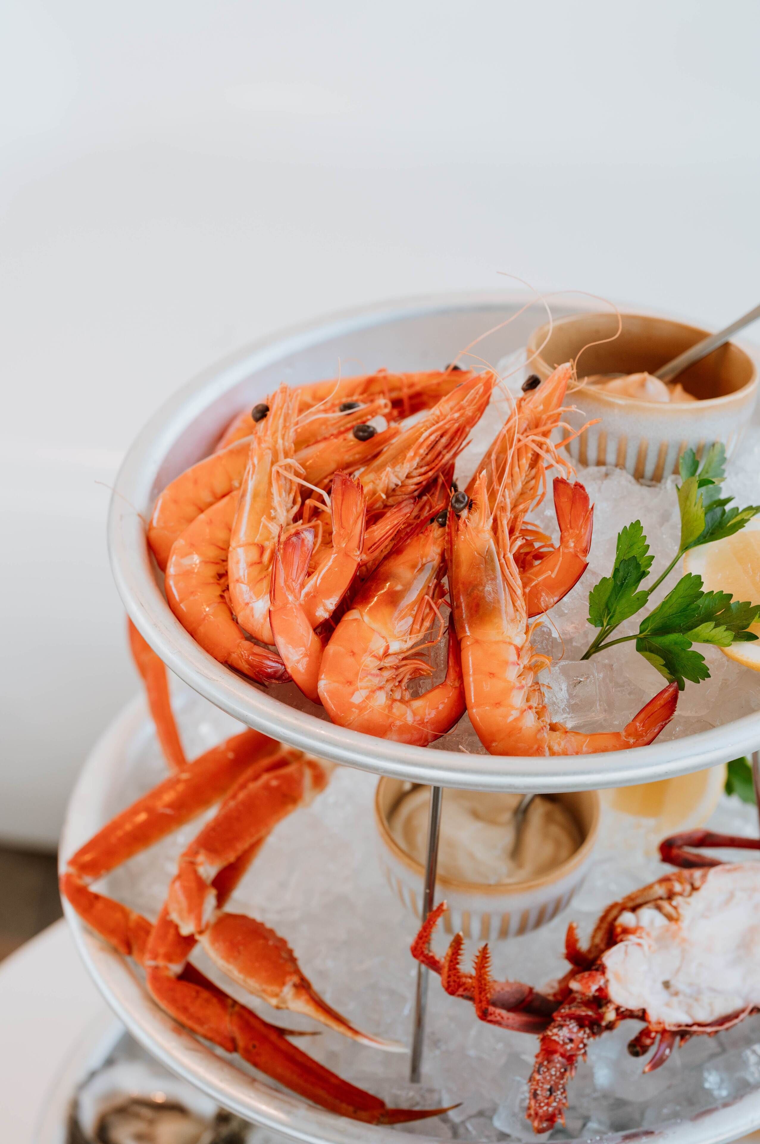 A seafood platter with shrimp and crab on ice, garnished with parsley.