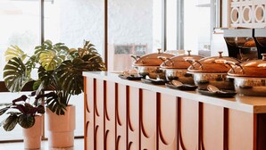 Zona de recepción con mostrador, plantas en macetas y vista al exterior.