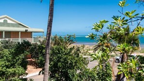Propiedad frente a la playa con un edificio de techo inclinado y un balcón.