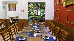 Ein Essbereich mit einem langen Tisch, gedeckt für eine Mahlzeit, umgeben von Holzstühlen.